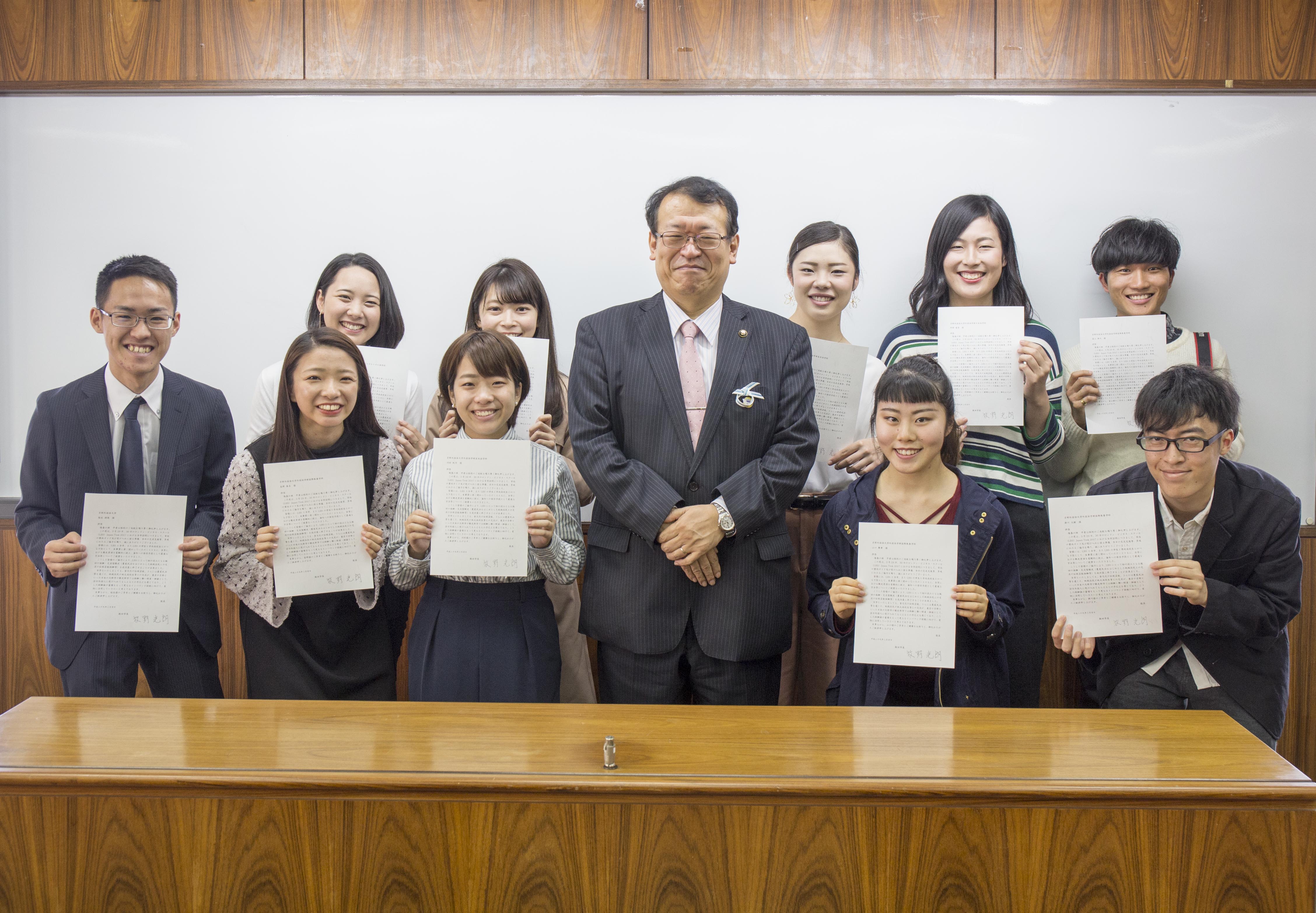 牧野光朗・飯田市長（中央）から感謝状を受け取った学生ら